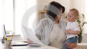 Working mother with baby boy at home office