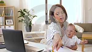 Working mother with baby boy at home office