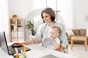 Working mother with baby boy and laptop at home