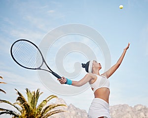 Working on my serve today. young tennis player standing alone on the court and serving the ball during practice.