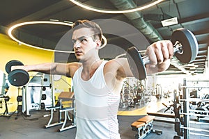 Working out with dumbbell weights at the gym.Fitness men exercising are lifting dumbbells. Fitness muscular body