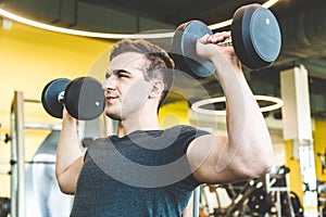 Working out with dumbbell weights at the gym.Fitness men exercising are lifting dumbbells. Fitness muscular body