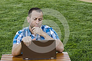 Working outdoors on a lap top computer.