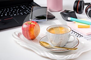 Working place and office desk with coffee, apple, laptop, headset and smarthpone