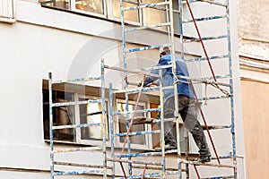 Working plasterer working on the scaffolding at the wall