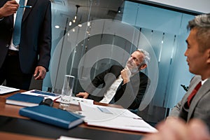 Working with pleasure. Happy mature businessman in formal wear listening to his colleague and smiling while having a