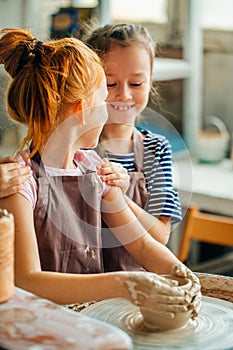 Working process with clay potter wheel. Two girls making pottery in studio