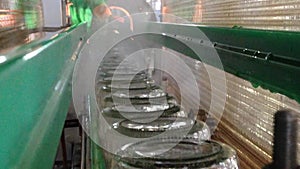 Working process of the production of cucumbers on cannery. Pasteurization of cans. Movement on the conveyor