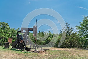 Working pump jack pumping crude oil at oil drilling site in rural USA