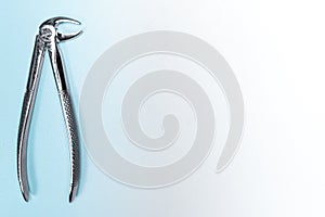Working real dental forceps from dental equipment tools. Light blue background with copy space.
