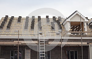 working on the roof sheeting and outriggers or ladder of a new, two story, commercial apartment building