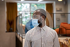 Working safely during coronavirus. Portrait of young afro american man, male office worker wearing protective face mask