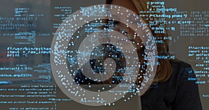 Working software developer coding on laptop in workspace, with blue code data visualization network