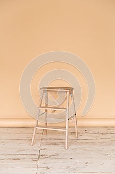 The working space of the photo studio with a beige paper background and chair.