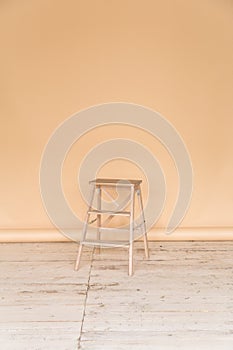 The working space of the photo studio with a beige paper background and chair.