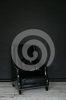 The working space of the photo studio with a black paper background and black armchair.