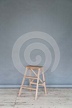 The working space of the photo studio with a grey paper background and chair.