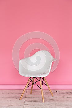 The working space of the photo studio with a pink paper background and chair.
