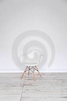 The working space of the photo studio with a white paper background and chair.
