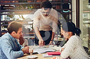Working on these stats together will make it better. Cropped shot of designers having a meeting at a coffee shop.