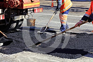 The working team renews a portion of asphalt with shovels in road construction