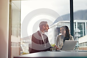 Working through their business process. two office businesspeople having an office meeting.