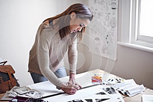 Working to create the perfect portfolio. A young woman working on her portfolio at home.