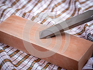 Wood carving chisel getting sharpened on a stone