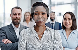 Working together to bring glory for all. Portrait of a businesswoman standing in an office with her colleagues in the