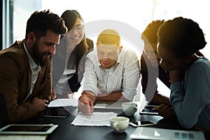 Working together to win together. a group of colleagues having a meeting in an office.