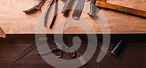Working tools on leather craftman`s work desk
