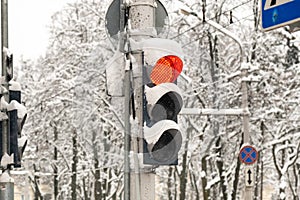 A working traffic light on a city street in winter.The red light of the traffic light is on