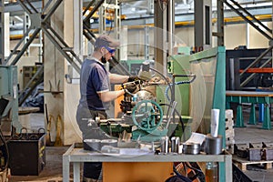 A working turner sets a part on a lathe