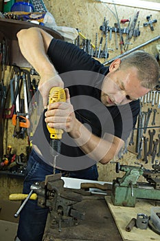 Working with a vise and drill. The master uses a drill. Portrait of a master at work