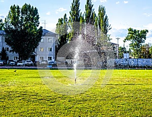 Working water automatic lawn irrigator under green football field