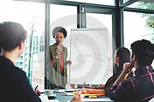 Working through ways to expand their growth as a team. a businesswoman giving a presentation to her colleagues in an