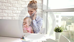 Working woman with baby speaking phone. Business mom with child