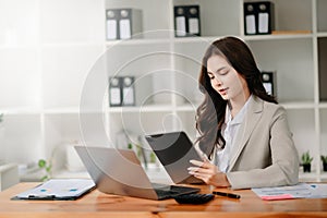 Working woman concept a female manager attending video conference and holding tablet, smatrphone and cup of coffee