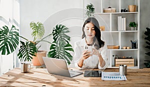 Working woman concept a female manager attending video conference and holding tablet, smatrphone and cup of coffee in home