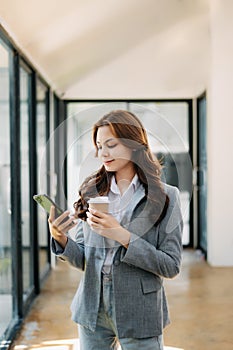 Working woman concept a female manager attending video conference and holding tablet, smatrphone and cup of coffee in office