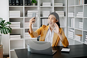 Working woman concept a female manager attending video conference and holding tablet, smatrphone in modern office