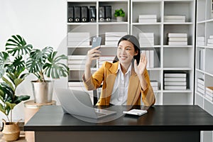 Working woman concept a female manager attending video conference and holding tablet, smatrphone in modern office