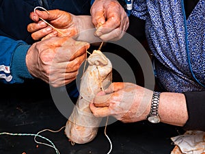 Working women filling the cecum of the pig with chopped and seasoned pieces from the cutting of the pig photo