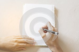 Working women holding a pens writing a notebook.