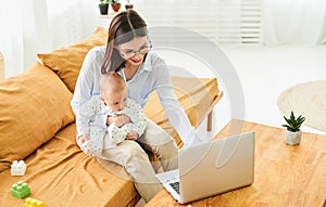 A working young mother with a laptop and a baby