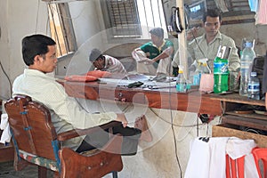 Workless Cambodian barber looks into mirror