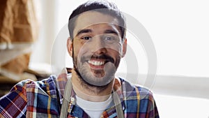 Workman in checkered shirt and apron at workshop