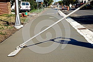 Workman finishes and smooths concrete surface on new sidewalk