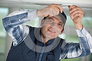 workman fitting spotlight in ceiling