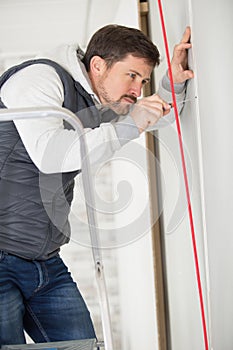 workman fixing beading to wall